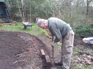 Paul digs out the edge to provide support for the log rolls.